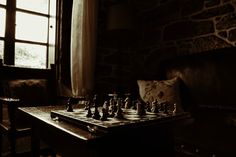 a chess set up on a table in front of a window