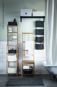 a bathroom with white tiles and black accessories on the shelf next to the bathtub