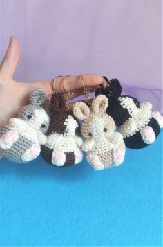 small crocheted animal keychains are being held by a person's hand