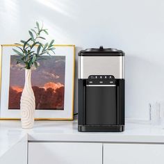 a black and silver water dispenser sitting on top of a white counter