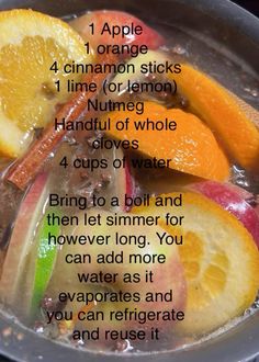 an apple cinnamon sticks recipe in a pot filled with water and orange slices on the side