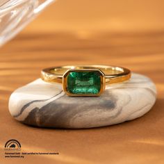 Expertly crafted with a vivid 1.36 carat Zambian emerald set horizontally, the Latitude Emerald Ring exudes elegance. Made with Fairmined yellow gold, this vibrant ring is both luxurious and socially responsible. Own a piece of beautiful jewelry while supporting ethical mining practices. Design Specifications: Type: Ring Material: 18 karat Fairmined yellow gold Width: 2.4mm Thickness: 2mm Finish: Polished Profile: Flat with rounded edges Setting Style: East/West Bezel Stone Specifications: Type: Luxury Solitaire Emerald Ring In Yellow Gold, Luxury Yellow Gold Emerald Solitaire Ring, Modern Yellow Gold Emerald Ring For May Birthstone, Fine Jewelry Emerald Ring With Tension Setting, Radiant Cut Yellow Gold Emerald Ring For May Birthstone, Gold Radiant Cut Gia Certified Emerald Ring, Radiant Cut Emerald Ring In Yellow Gold, Gia Certified Radiant Cut Gold Emerald Ring, Modern Yellow Gold Emerald Ring