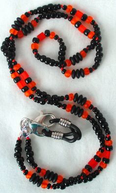 You'll always keep track of your reading glasses when using this orange & black beaded eyeglass chain! 25" in length, made with glass beads, beading cord, metal lobster clasps, and adjustable rubber holders. Lobster clasps make it easy to change the rubber holders, and an extra pair of holders included with every purchase. This orange & black beaded eyeglass chain will arrive in a gift box, ready to give as a present or to keep and store. Back to Beaded Eyeglass Chains Black Glass Beaded Necklaces With Colorful Beads, Black Glass Beaded Necklace With Colorful Beads, Black Glass Beaded Necklaces With Beaded Chain, Black Glass Beaded Necklace With Beaded Chain, Adjustable Double Strand Black Beaded Necklace, Black Glass Beaded Necklace, Adjustable Czech Glass Beaded Necklaces With Lobster Clasp, Adjustable Black Czech Glass Jewelry, Adjustable Black Beaded Glass Necklaces