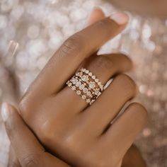 a woman's hand with three rings on her fingers and two diamonds in the middle