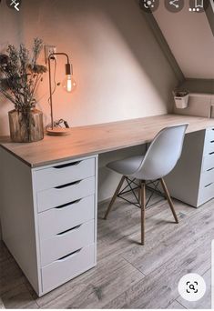 a desk with two chairs and a lamp on top of it in an attic room