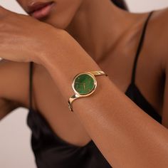 Claire's unique ring-like shape and hidden crown make it look more like a bracelet than a watch. The genuine jade dial pairs beautifully with the polished yellow gold bangle. Material: Stainless Steel Finishing: 23k Gold Plating Dial: Genuine Jade Movement: Swiss Ronda Quartz Glass: Hardened Mineral Crystal Water Resistance: 3 ATM Emerald Watch Women, Womens Jewelry Watch, Vintage Watches Women, Crystal Water, Yellow Gold Bangle, Bangle Watches, Jade Bangle, Classy Jewelry, Watches Unique