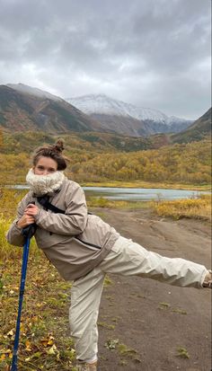 a woman is doing yoga in the mountains