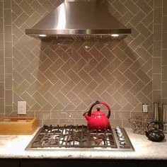 a red tea kettle sitting on top of a stove