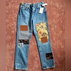 an old pair of jeans with patches and flowers on them are sitting on the floor