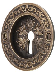 an ornate door knob with a keyhole in the center and floral designs on it