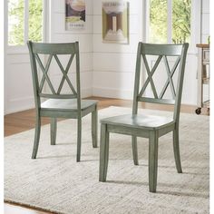 two green chairs sitting on top of a rug