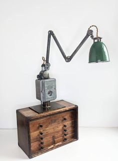 an old fashioned desk lamp sitting on top of a wooden chest