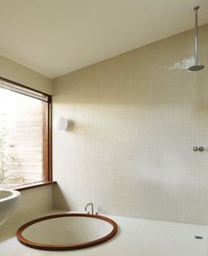 a bath room with a tub and a sink under a window next to a toilet