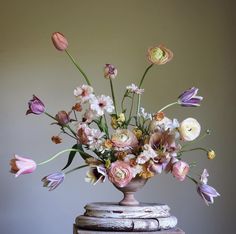 a vase filled with lots of flowers sitting on top of a table