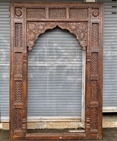 an ornate carved wooden arch in front of a garage door