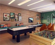 a game room with pool tables, couches and pictures on the wall above it