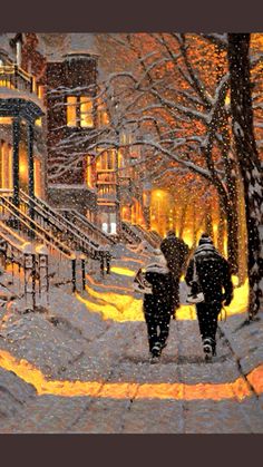 two people walking down a snowy street at night