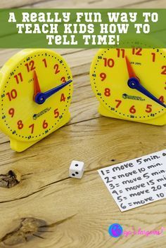 two yellow clocks sitting on top of a wooden table next to dices and paper