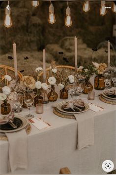 the table is set with candles, plates and flowers