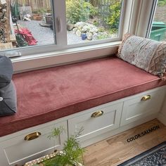 a window sill with a cushion on top of it next to a potted plant