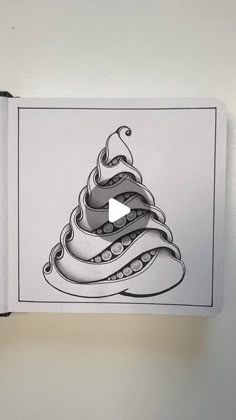 an open book with a drawing of a christmas tree on the page and a video playing below it