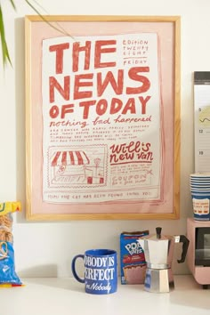 the news of today is displayed in front of a coffee maker and cups on a counter