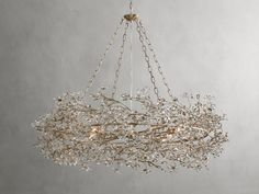 a chandelier with branches and lights hanging from it's center, against a gray background