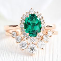 This strikingly gorgeous emerald engagement ring features an 8x6mm oval cut green emerald set in our Tiara Halo Diamond ring. The petite band gently tapers toward the emerald center surrounded by brilliant white diamonds, creating an elegant feminine curve. This unique oval emerald diamond ring is a perfect alternative engagement ring for brides who love earthy green gemstone rings. It can be crafted in your choice of platinum or 14k or 18k yellow, rose, or white gold. A matching bridal ring set Wedding Ring Goals, Halo Oval Ring, Rose Gold Emerald Ring, Peach Champagne Sapphire, Emerald Engagement Ring Green, Rose Gold Tiara, Emerald Set, Halo Diamond Earrings, Green Gemstone Ring