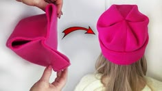 a woman wearing a pink hat with an arrow drawn on the front and back of it