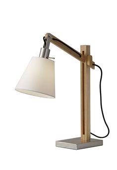 a desk lamp with a white shade on the base and a black cord attached to it