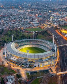 an aerial view of a stadium at night with the lights on in the foreground