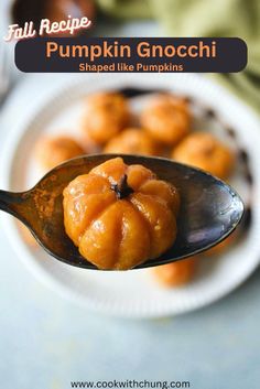 a spoon full of pumpkin gnocchini sitting on top of a white plate