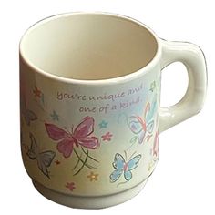 a coffee cup with butterflies painted on the side and words that read, you're unique and one of a kind