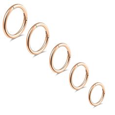 three pairs of rose gold rings on a white background