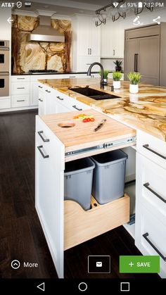 a kitchen with white cabinets and wooden counter tops, two trash cans on the island