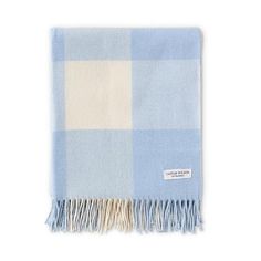 a light blue and white checkered blanket with fringes on the bottom, in front of a white background