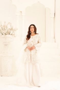 Elevate your ethnic style with our White Pearl Tassel Shalwar Kameez. Featuring a gorgeous short shirt adorned with delicate ivory lace work, paired with a frilly dupatta and a crush silk sharara. Experience comfort and elegance like never before. Elegant Lace Designer Wear Sets, Elegant Lace Sets For Designer Wear, Elegant Salwar Kameez With Lace Work For Festive, Elegant Lace Salwar Kameez For Eid, Eid Lace Sets With Resham Embroidery, Semi-stitched Lace Sets For Eid, Elegant Cream Sets With Lace Work, Elegant Lace Sets For Eid, Eid Lace Sets With Dabka Work