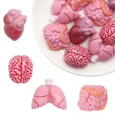 a white plate topped with pink and red candies next to two heart shaped candy molds