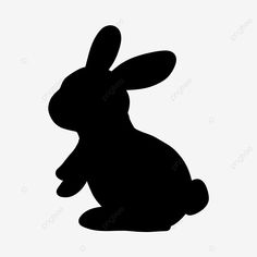 a silhouette of a rabbit sitting down on the ground with its head turned to the side