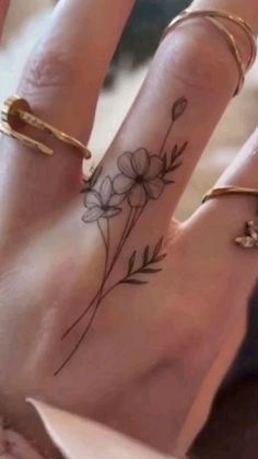 two fingers with flowers on them and gold rings