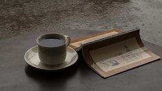 a cup of coffee sitting on top of a table next to an open book and envelope