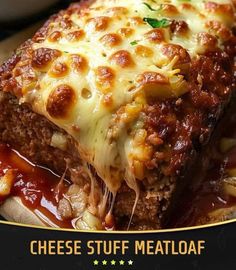 a close up of a piece of meatloaf on a plate with sauce and cheese