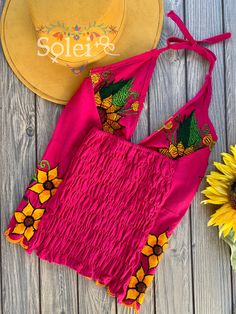 This Beautiful Sunflower Embroidered Halter Top is the perfect Top for Everyday use or a special event. It is comfortable, with elastic on the back and has a tie around the neck for an adjustable fit. This blouse comes in one size which fits sizes Small and Medium. Fitted Pink Embroidered Top With Floral Details, Fitted Pink Top With Floral Embroidery, Fitted Pink Embroidered Top For Summer, Summer Embroidered Top With Floral Print, Multicolor Embroidered Floral Top For Summer, Multicolor Embroidered Floral Print Top For Summer, Fitted Embroidered Top For Summer Beach, Fitted Floral Embroidered Top For Summer, Fitted Floral Embroidered Top For Festival