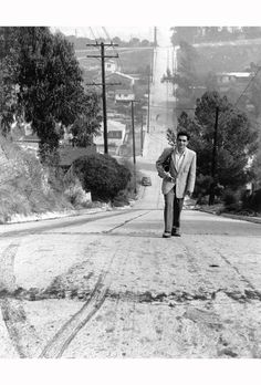 a man in a suit is walking down the street