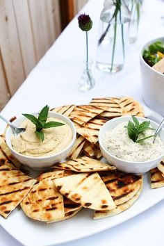 some pita bread and dips on a white plate