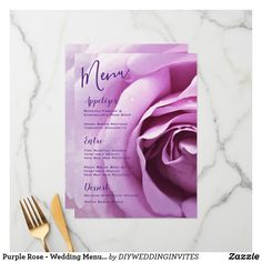 a menu card with a purple rose on it next to a gold fork and knife