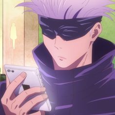 a man with purple hair is looking at his cell phone