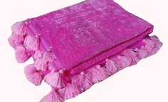 two pink blankets with tassels on them