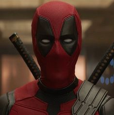 the deadpool character has two swords in his hand and is wearing a red costume