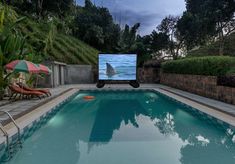 an outdoor swimming pool with a large screen tv